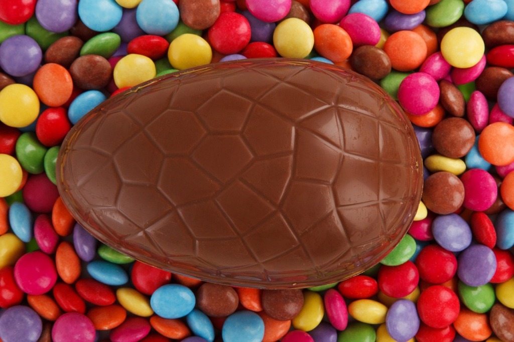 Chocolate Easter egg on a bed of colourful Smarties.